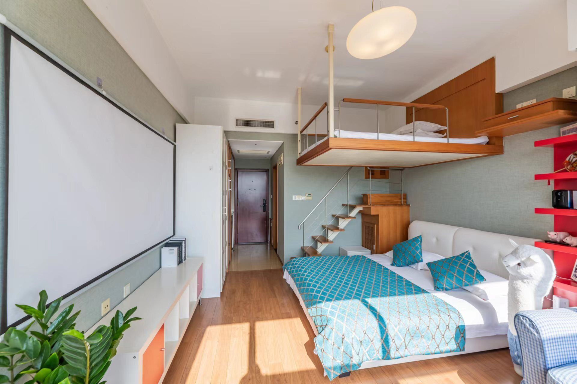 A compact, modern bedroom with a bunk bed, a sofa, and a desk area.