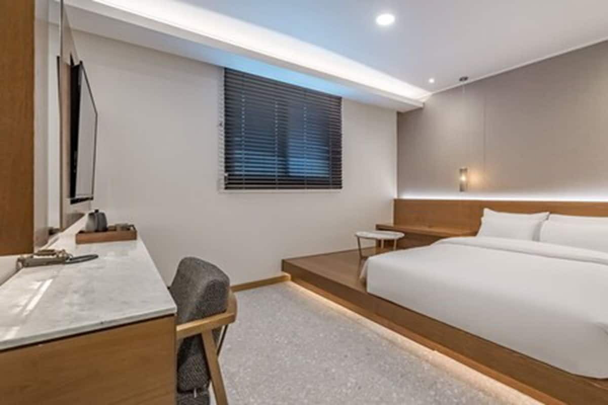 Habitación de hotel moderna con una cama grande, un escritorio y una mesita.