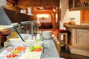 A buffet setup with various food items and a glass display case. - Hotel Engel (Alberschwende)