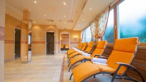Un vestíbulo de hotel con una fila de sillones naranjas, un diseño de techo en forma de sol y ventanas grandes con cortinas.