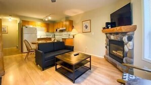 Un salon avec un canapé, une table basse et une cheminée.