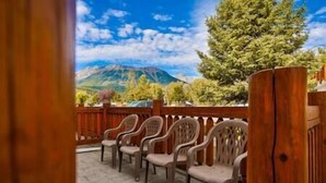 Un espace patio avec des chaises en bois et une vue sur une montagne.