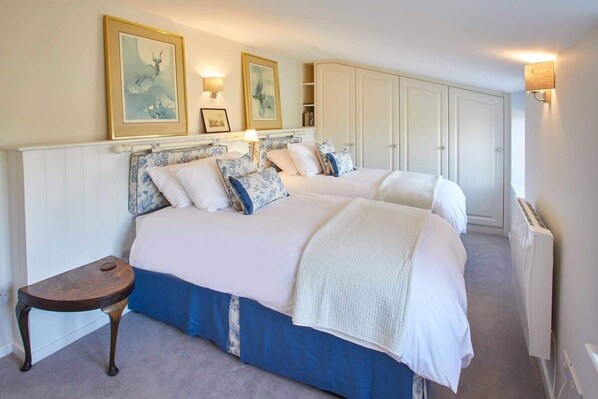 A bedroom with a large bed, a bedside table, and a wardrobe. - Host & Stay | Tithe Cottage (Harrogate)
