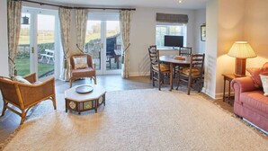 A spacious living room with a large window, a dining area, and a cozy seating area.