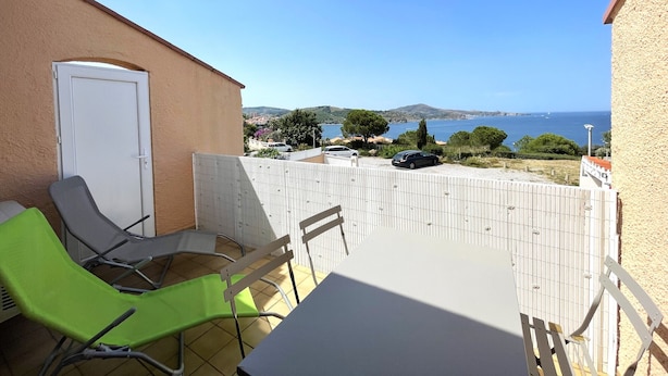A patio with a table and chairs, a white door, and a view of the sea and distant landscape. - BANYULS-SUR-MER, A/C T2, terrace, parking, near cove (Banyuls-sur-Mer)