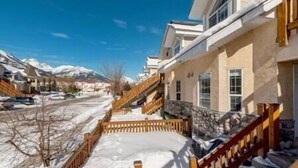 A residential building with a snow-covered driveway and a mountain backdrop. - Spacious Townhouse / Loft Access / Mountain Views (Fernie)