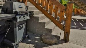 A barbecue grill with a wooden railing and steps leading up to it. - Spacious Townhouse / Loft Access / Mountain Views (Fernie)