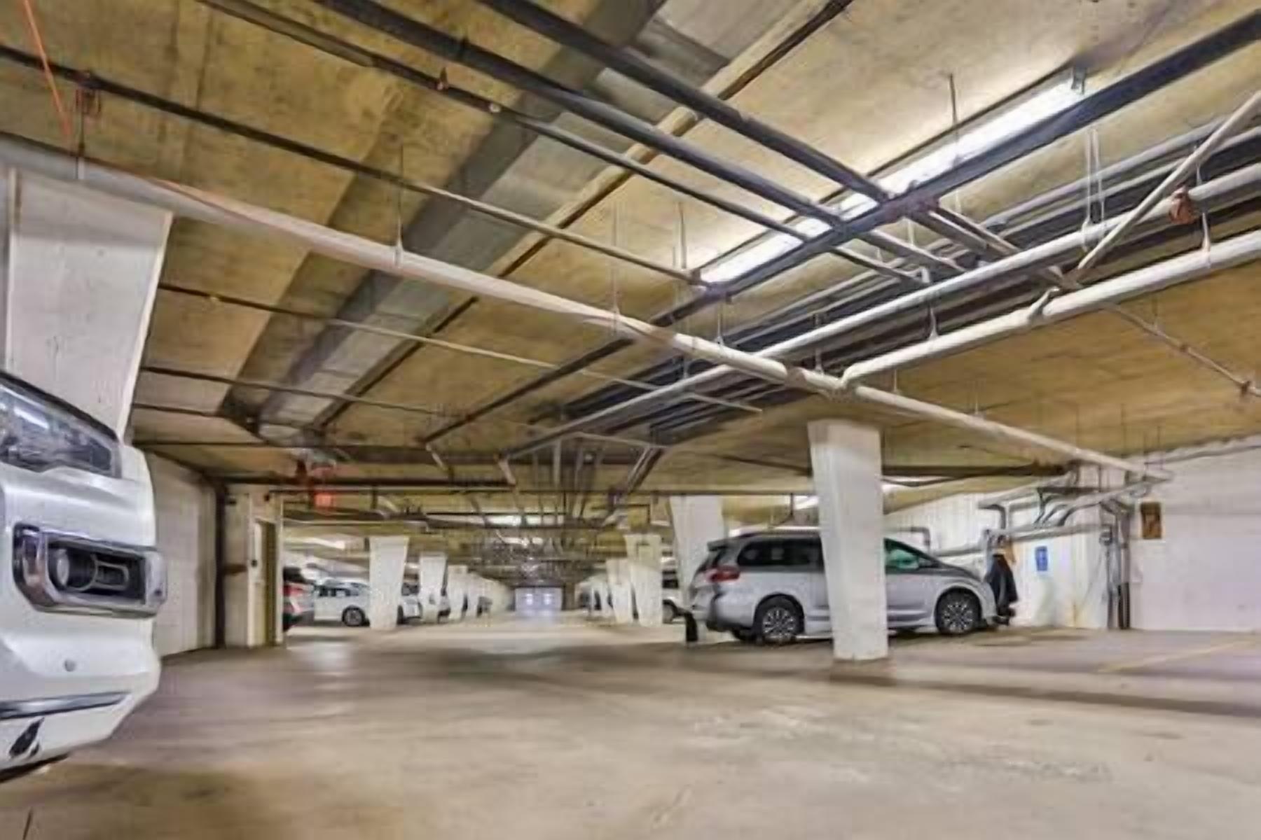 A multi-level parking garage with concrete pillars and overhead lighting.
