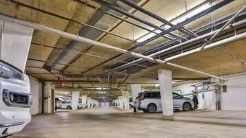 A multi-level parking garage with concrete pillars and overhead lighting.