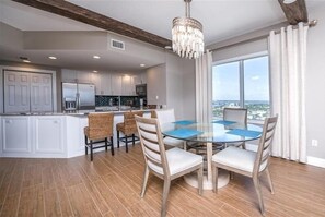 Enjoy meals in the spacious kitchen and dining area, featuring a central island, round table, and comfortable seating for four.