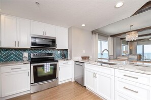 Enjoy cooking in this well-lit kitchen with a large island and stainless steel appliances.
