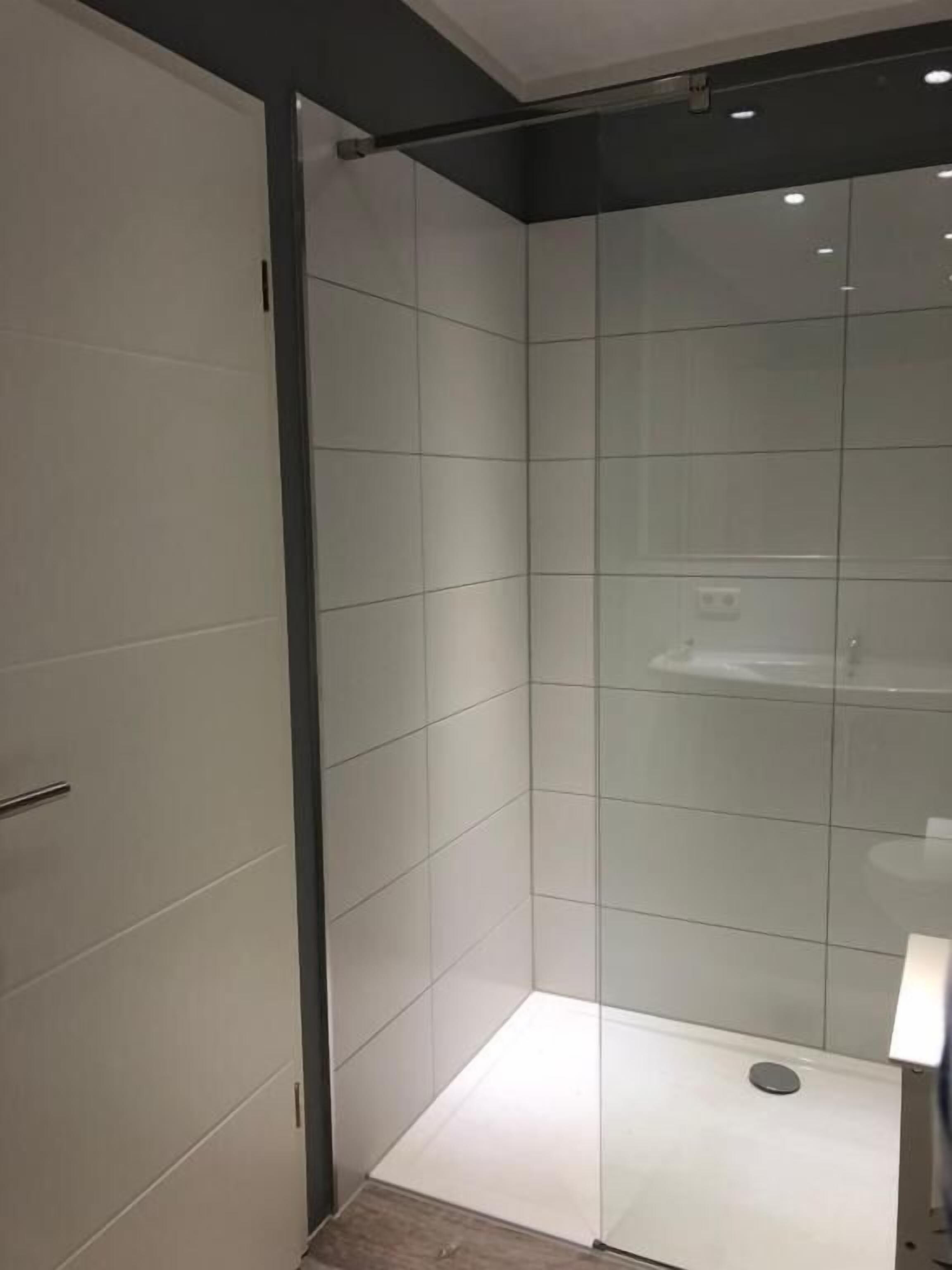 A modern shower area with glass walls and a tiled floor.