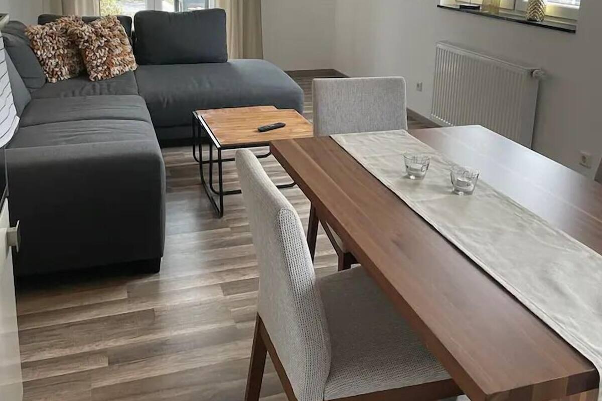 Een moderne woonkamer met een bank, een eettafel en een televisie.