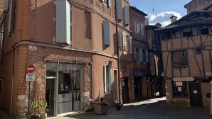 A cobblestone street with traditional European buildings, a closed shop with a bicycle sign, and a no entry sign. - Cathedral Aparthotel historic center cathedral view Superior (Albi)