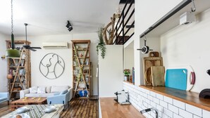A modern kitchen with a wooden countertop, a sink, and a dining area with a table set for two. - Modern Loft Retreat with Rooftop by Sea N Rent (Tel Aviv)