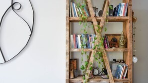 A wooden bookshelf with books and decorative items, including a small clock and figurines. - Modern Loft Retreat with Rooftop by Sea N Rent (Tel Aviv)