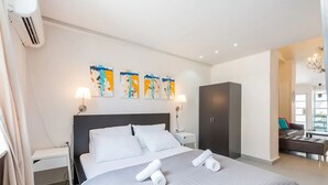 A modern hotel room with a large bed, a wardrobe, and abstract wall art. - Home of Art in Neve-Tzedek Heart (Tel Aviv)