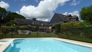 A swimming pool with a house in the background. - Adele cottage – lovely, spacious Breton cottage - shared pool, private garden (Ploërdut)
