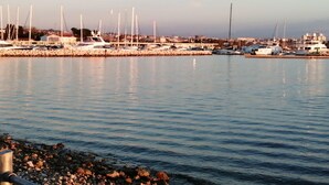 A marina with several yachts docked, a rocky shoreline, and a clear sky. - Holiday Home Stone Wall (Razanac)