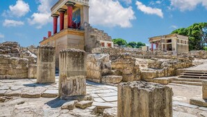 Ruinas antiguas con columnas y escalones de piedra, probablemente parte de un sitio histórico.