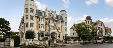 A hotel with a classic architectural style, featuring a prominent entrance with steps and a sign that reads "ASTORIA HOTEL".