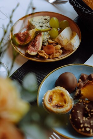 Ein Teller mit verschiedenen Speisen, darunter Käse, Nüsse und Obst.