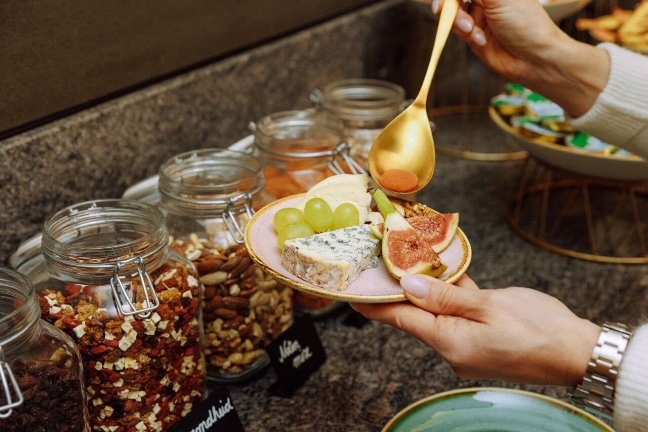 A buffet with various food items and a person serving themselves.