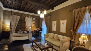 A cozy room with a bed, a sofa, a coffee table, and a chandelier. - Camino Real de Selores (Valle de Cabuerniga)