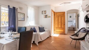 A cozy room with a bed, a dining table set for two, and a chair. - Stunning private villa for 4 people with WIFI, TV and terrace (Sanremo)