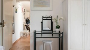 A hotel room with a bed, a desk with a chair, a wardrobe, and a framed picture on the wall. - Stunning private villa for 4 people with WIFI, TV and terrace (Sanremo)