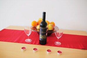 A bottle of Takler Regnum wine on a table with two glasses and a bowl of fruit. - Bech Apartment - 4 Persons (Posedarje)