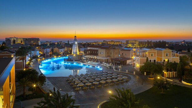Un resort con piscina, tumbonas y una torre.