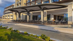 Un hotel con terraza exterior, piscina y diseño arquitectónico moderno.