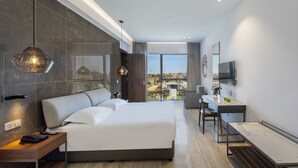 Un hotel moderno con una cama grande, un escritorio y vistas a la ciudad.