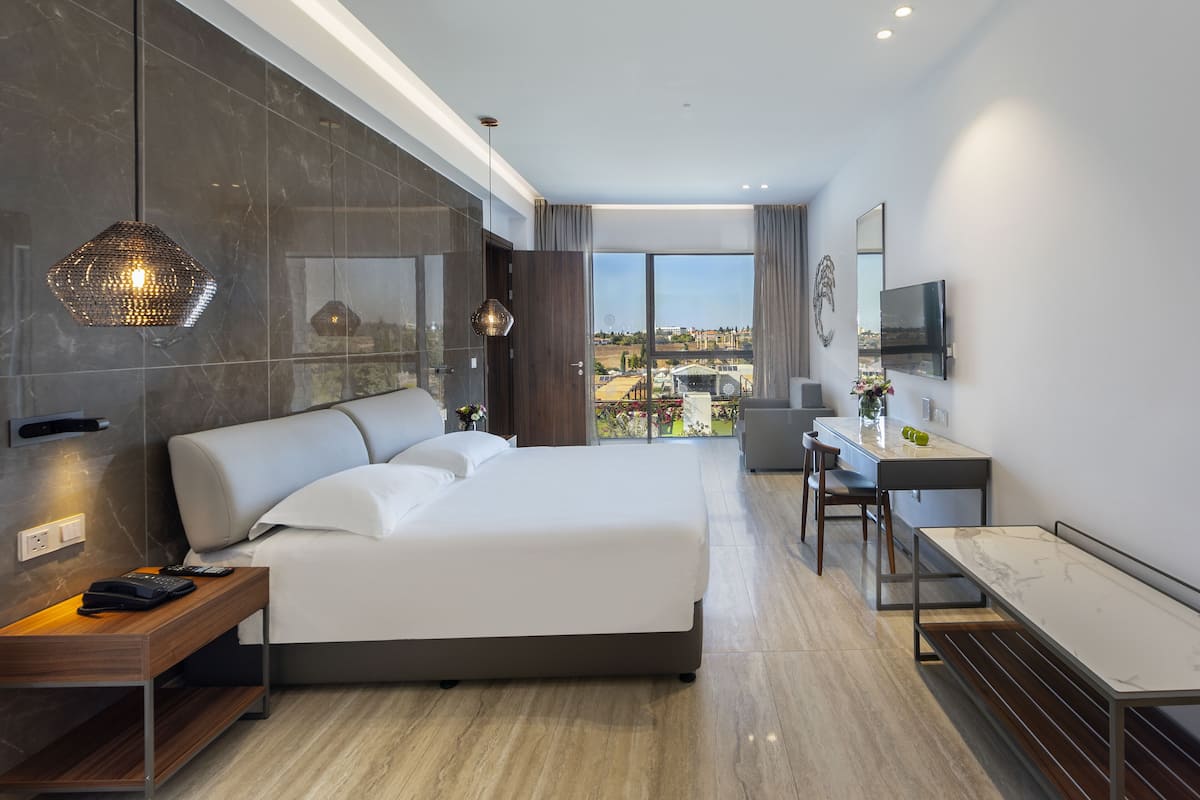 Une chambre d’hôtel moderne avec un grand lit, un bureau et une vue sur la ville.