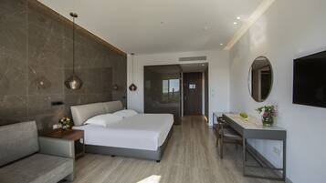 Una habitación de hotel moderna con cama, sofá, escritorio y televisor.