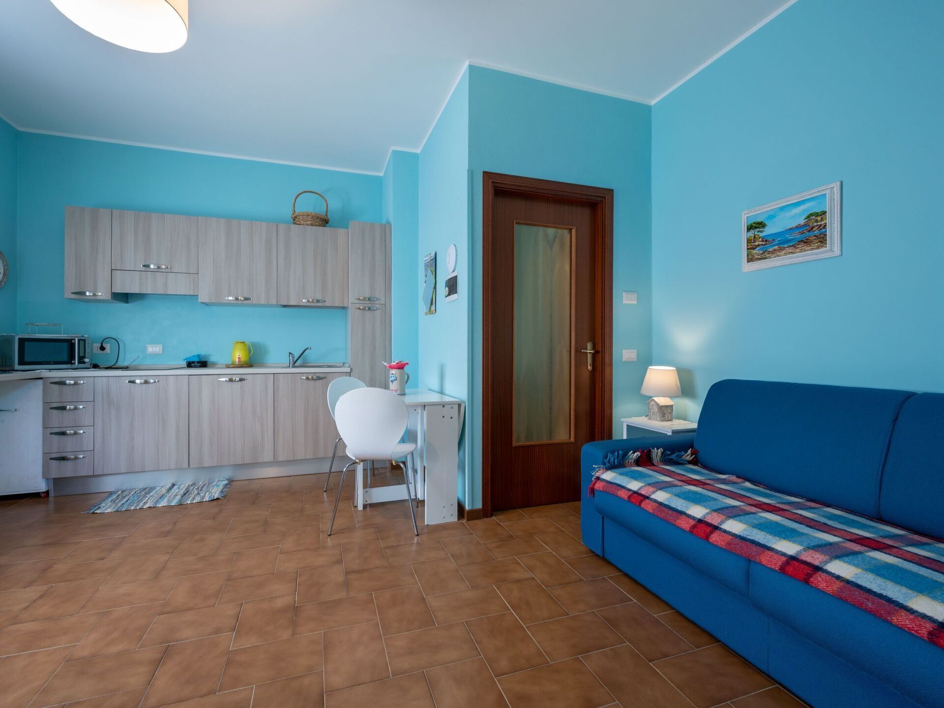 A compact living space with a kitchenette, a dining area, and a sofa.