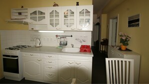 A kitchen with white cabinets, a stove, and a sink. - Apartment No. 7 Horova 8 (Karlovy Vary)