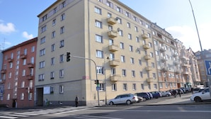 A multi-story residential building with balconies, a pedestrian crossing, and parked cars. - Apartment No. 7 Horova 8 (Karlovy Vary)