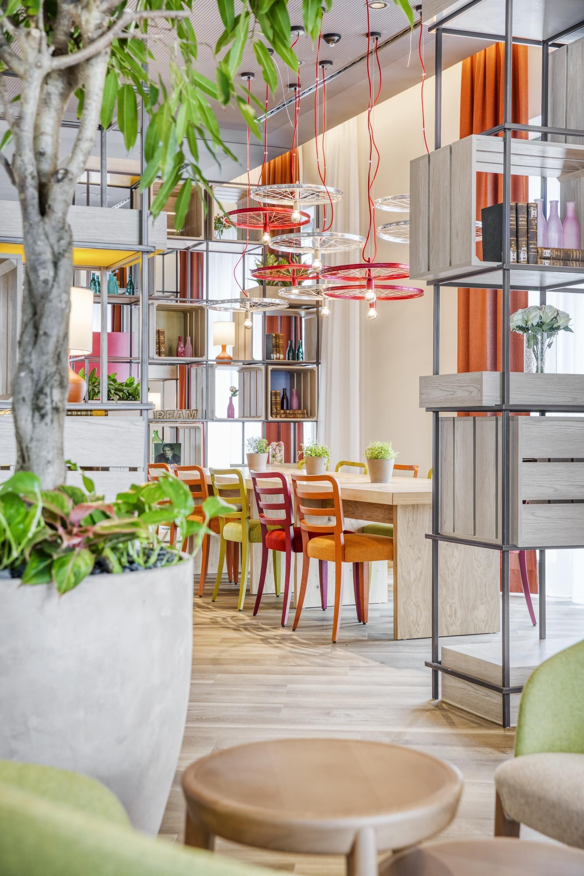 Ein modernes Interieur mit Essbereich, Holzmöbeln und einer großen Topfpflanze.
