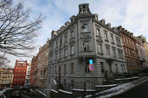 A historic building with classical architecture, featuring a corner entrance and a prominent blue sign. - Apartment No. 16A Svahová 14 (Karlovy Vary)