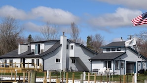 Ett tvåvåningshus med en brygga, en flagga och en klar himmel.