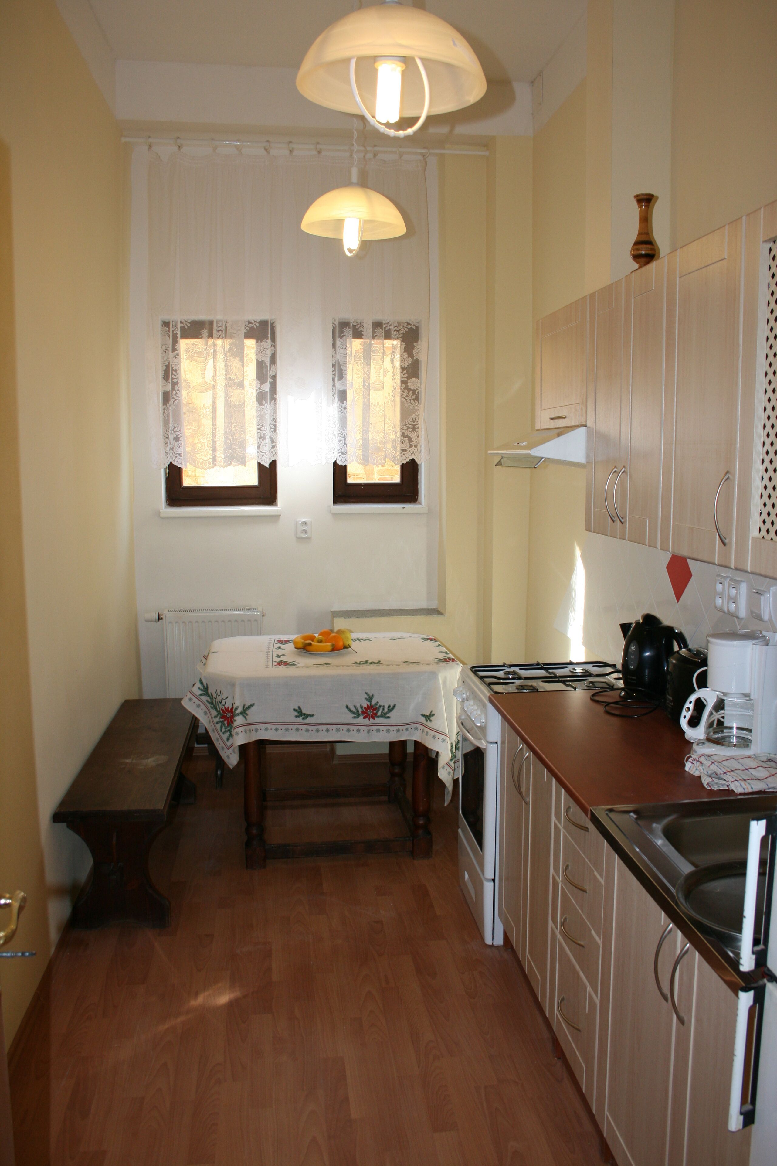 A compact kitchen with a wooden table, a stove, and cabinets.