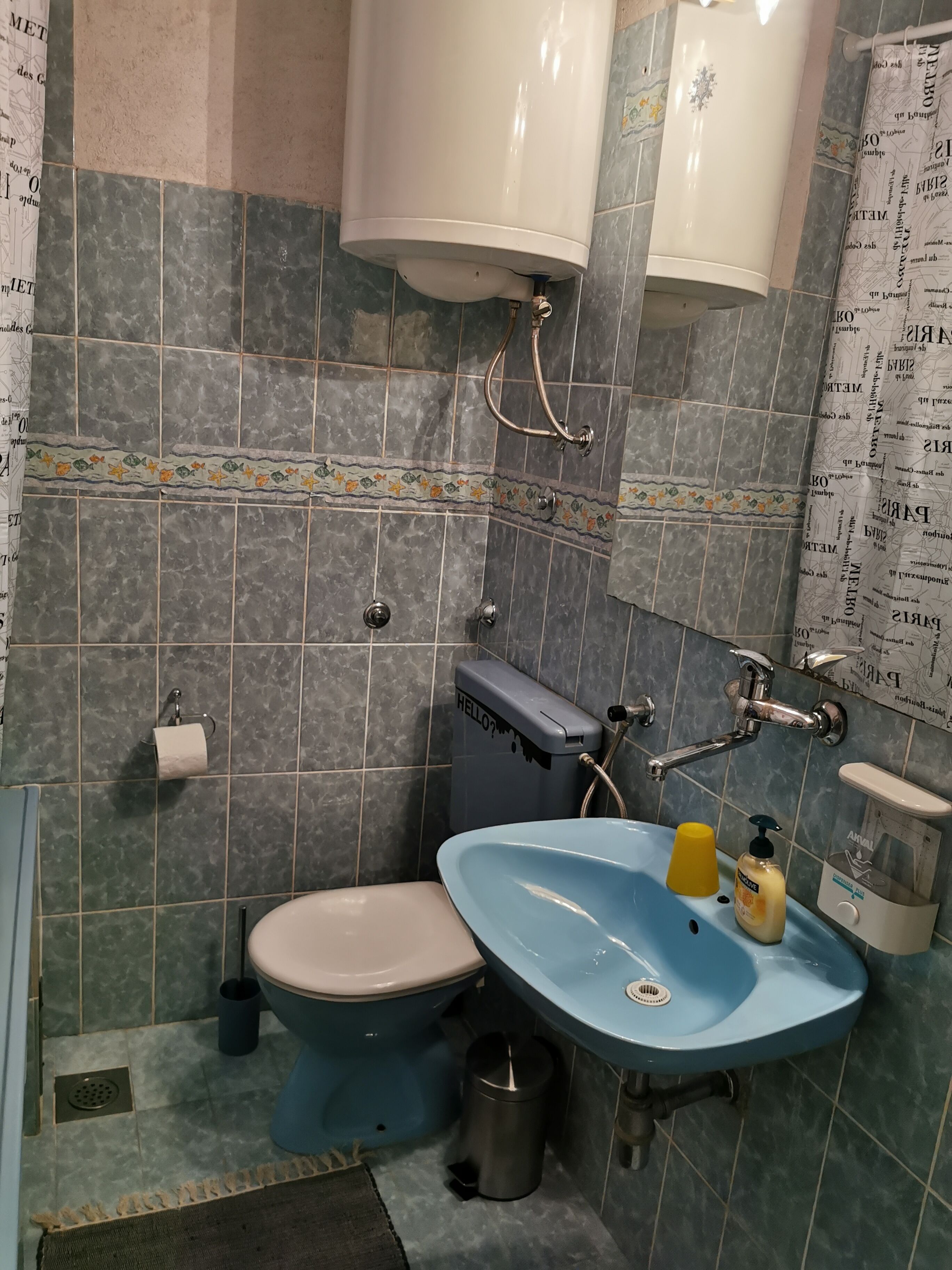 A bathroom with a toilet, sink, and shower.