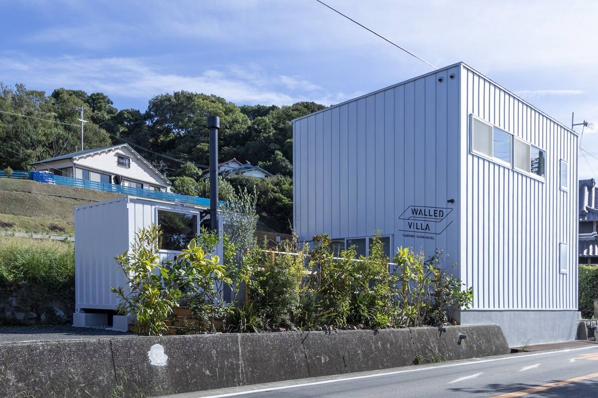 A modern building with a sign reading "Walled Villa Kamome Slow Hotel".