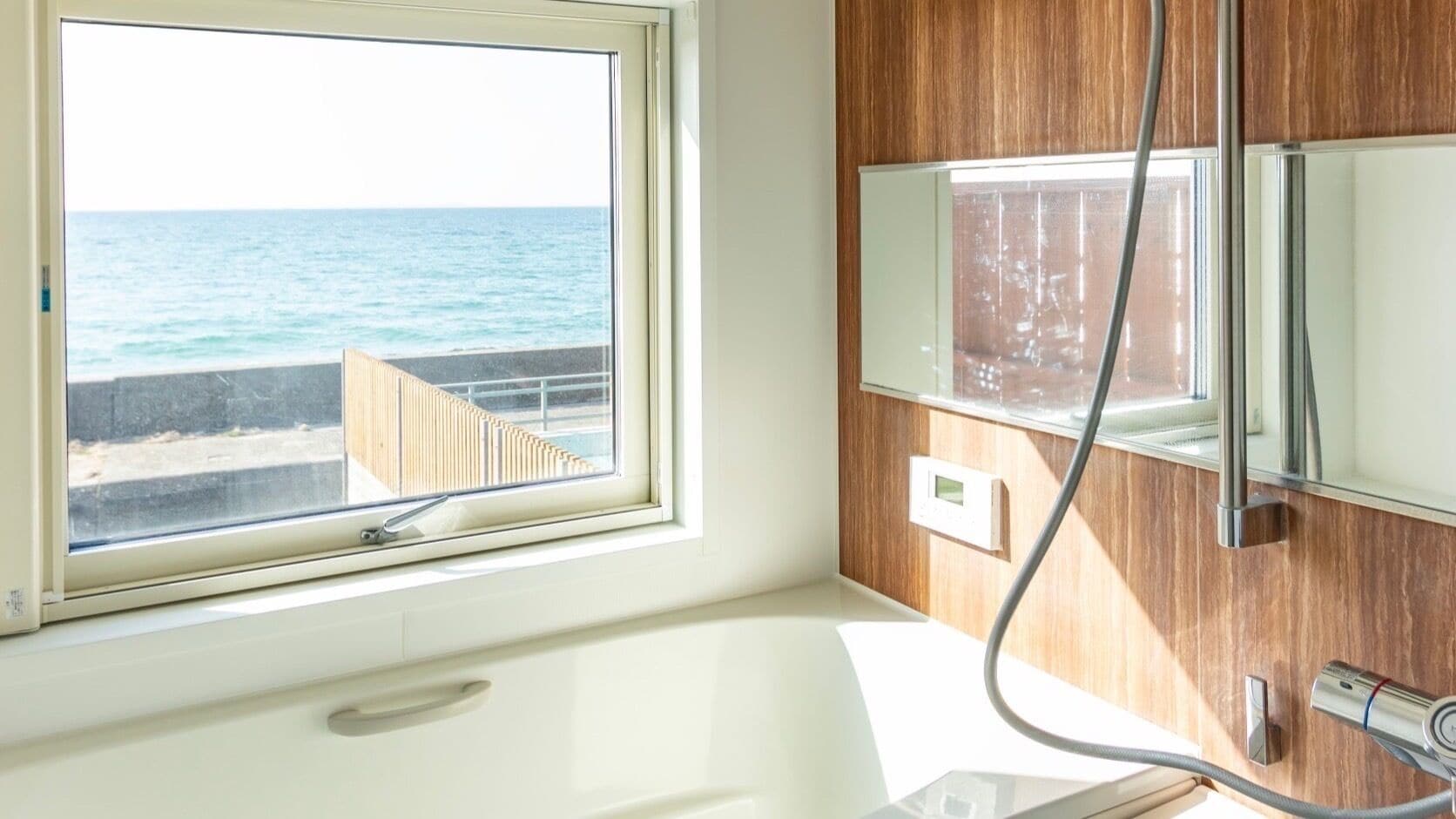 A bathroom with a view of the sea, a built-in heater, and a towel rack.