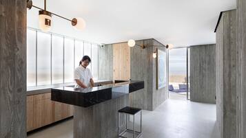 Een moderne keuken met een centraal eiland, houten kastjes en een groot raam met uitzicht.