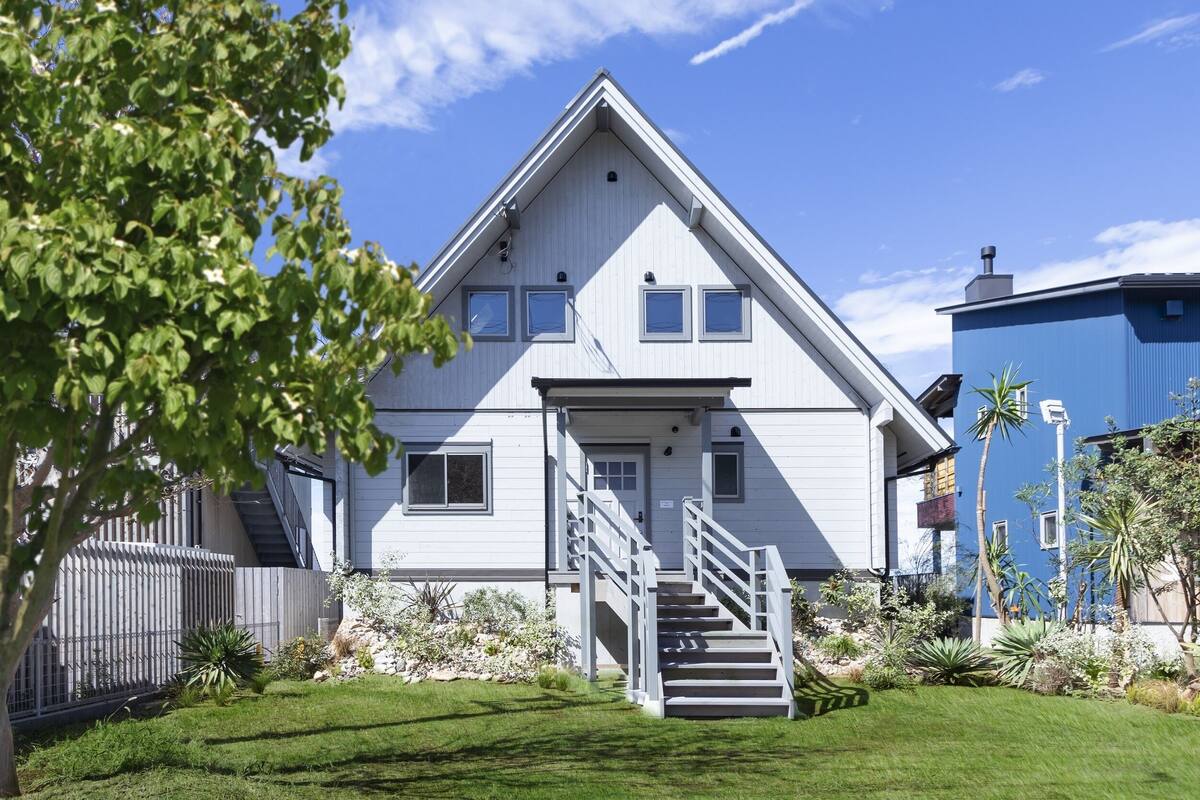 A two-story house with a front porch, a staircase, and a well-maintained garden.