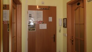 A hallway with wooden doors, a black tiled floor, and yellow walls. - Apartment No. 22 Zeyerova 15 (Karlovy Vary)