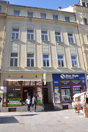 A building with multiple windows and a storefront labeled "Blue Style Travel Agency". - Apartment No. 22 Zeyerova 15 (Karlovy Vary)